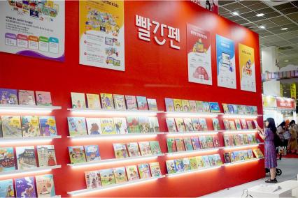 11일 서울국제유아교육전 전시회에서 교원 빨간펜 부스 내 미니도서관에서 학부모가 책을 고르고 있다. (사진 = 위즈경제)