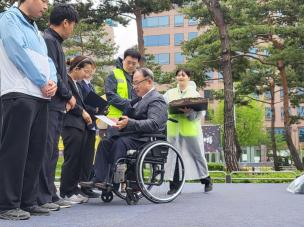 20일 여의도 국회 앞에서 열린 '시설 거주 장애인 권리선포대회' 중 진행된 '권리주장대회'에서 한국장애인복지시설협회 김광식 회장(휠체어 탄 이)이 '시설 거주 장애인 권리주장대회' 무대에 오른 5명의 당사자 중 한 명에게 상장과 부상을 수여하고 있다. 사진=위즈경제