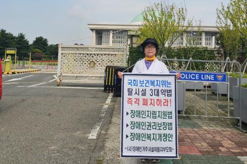 지난 23일, 탈시설 3법안에 반대하며 국회 앞에서 시위를 진행한 변현숙 씨의 모습 (사진 = 변현숙)